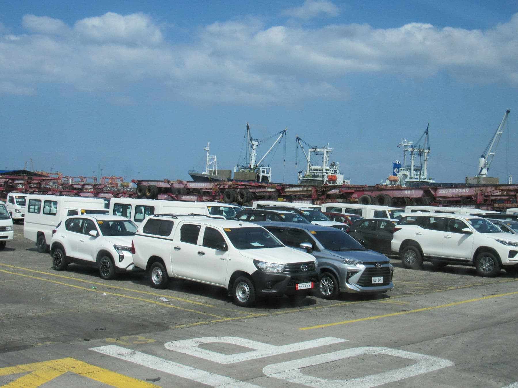 Rows of new vehicles waiting at a port terminal for export